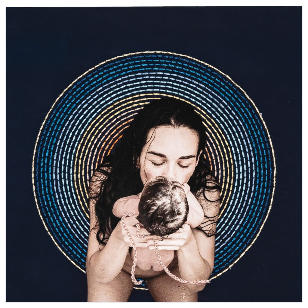 Portada del libro - Tejer el Pensamiento Materno. Una madre cargando a su recién nacida hija, aun unidas por el cordón umbilical. De fondo, una representación tejida del cordón umbilical.