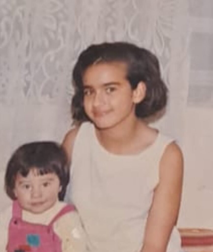 Alejandra de niña con su hermana menor